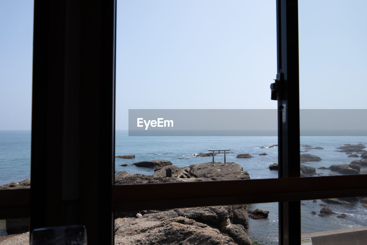 SEA AGAINST CLEAR SKY SEEN THROUGH WINDOW