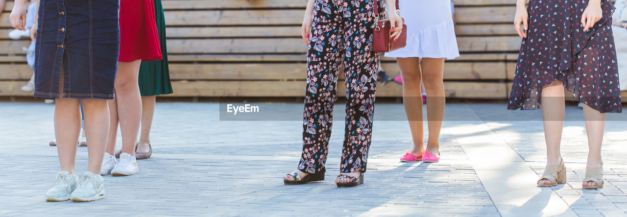 LOW SECTION OF WOMAN STANDING ON FLOOR