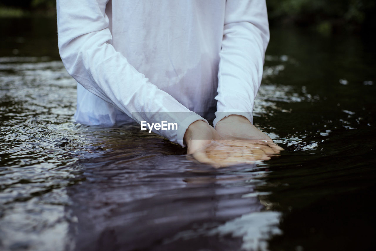 Midsection of man standing in water