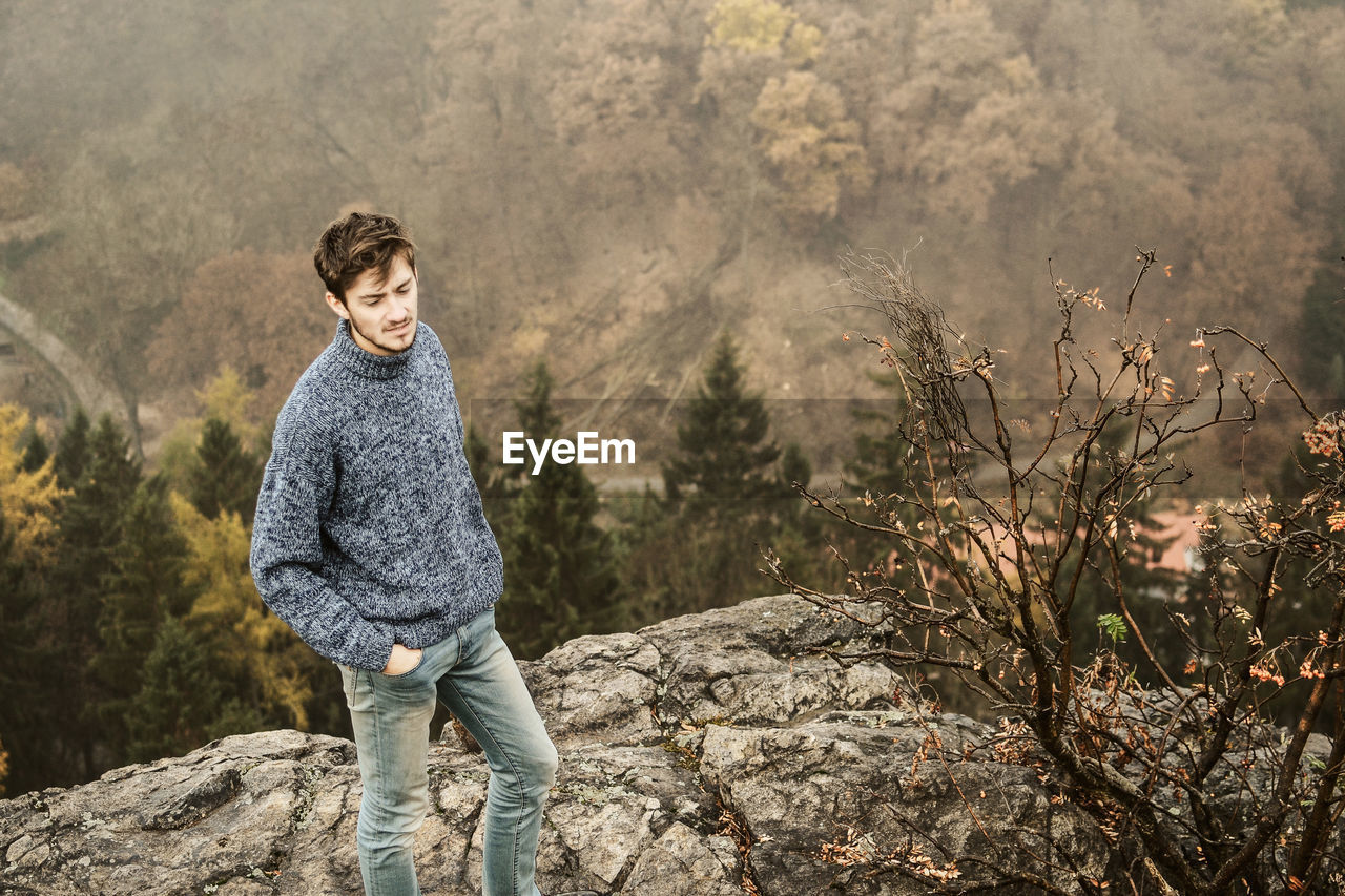 Portrait of a young man standing on mountain in autumn