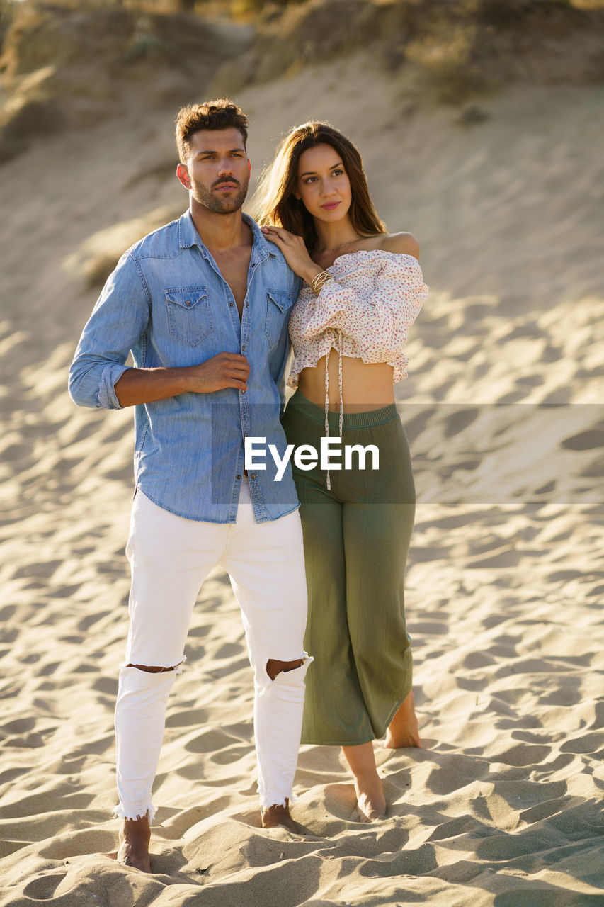 Full length of young couple standing on beach