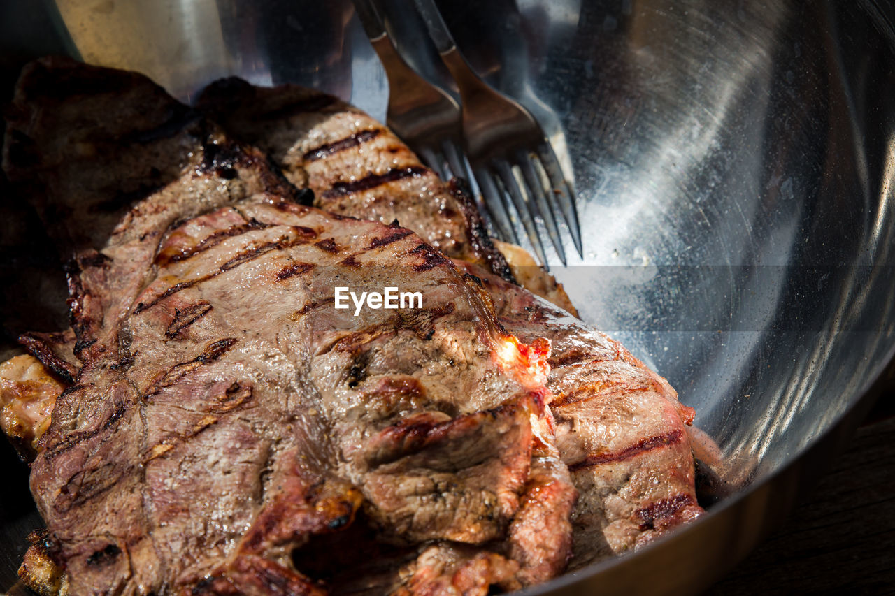 CLOSE-UP OF MEAT COOKING ON BARBECUE