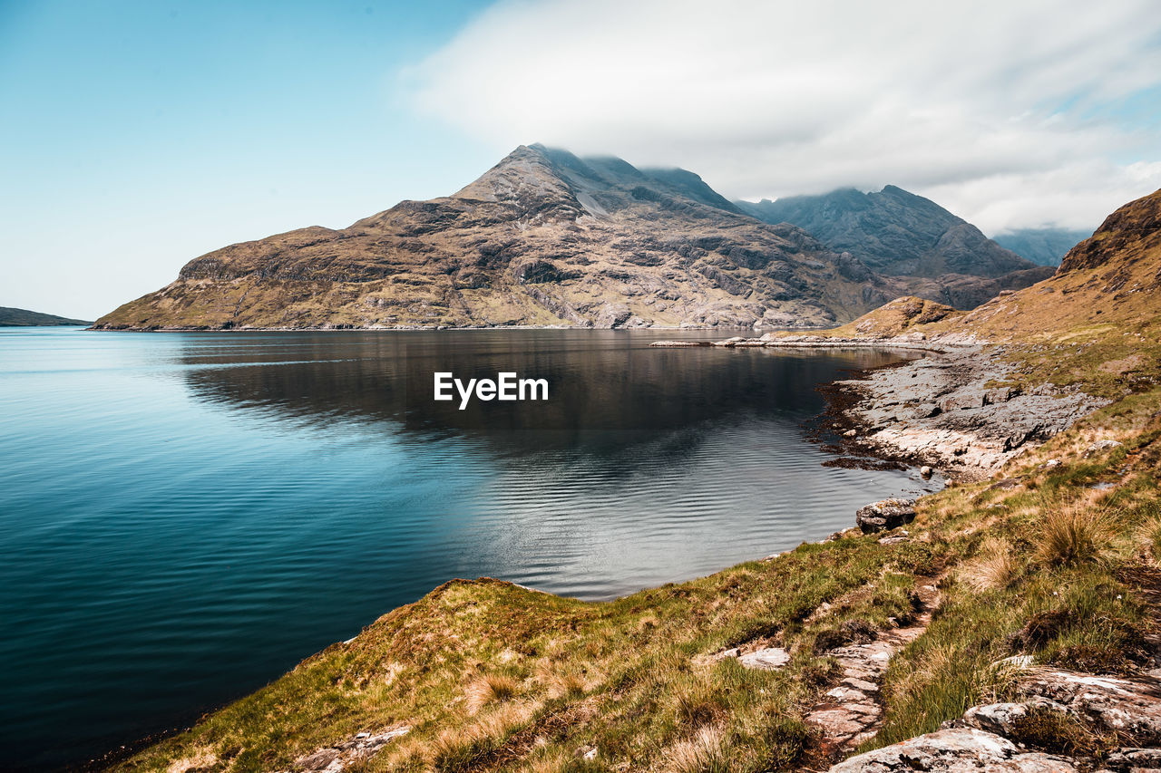 Scenic view of sea and mountain against sky