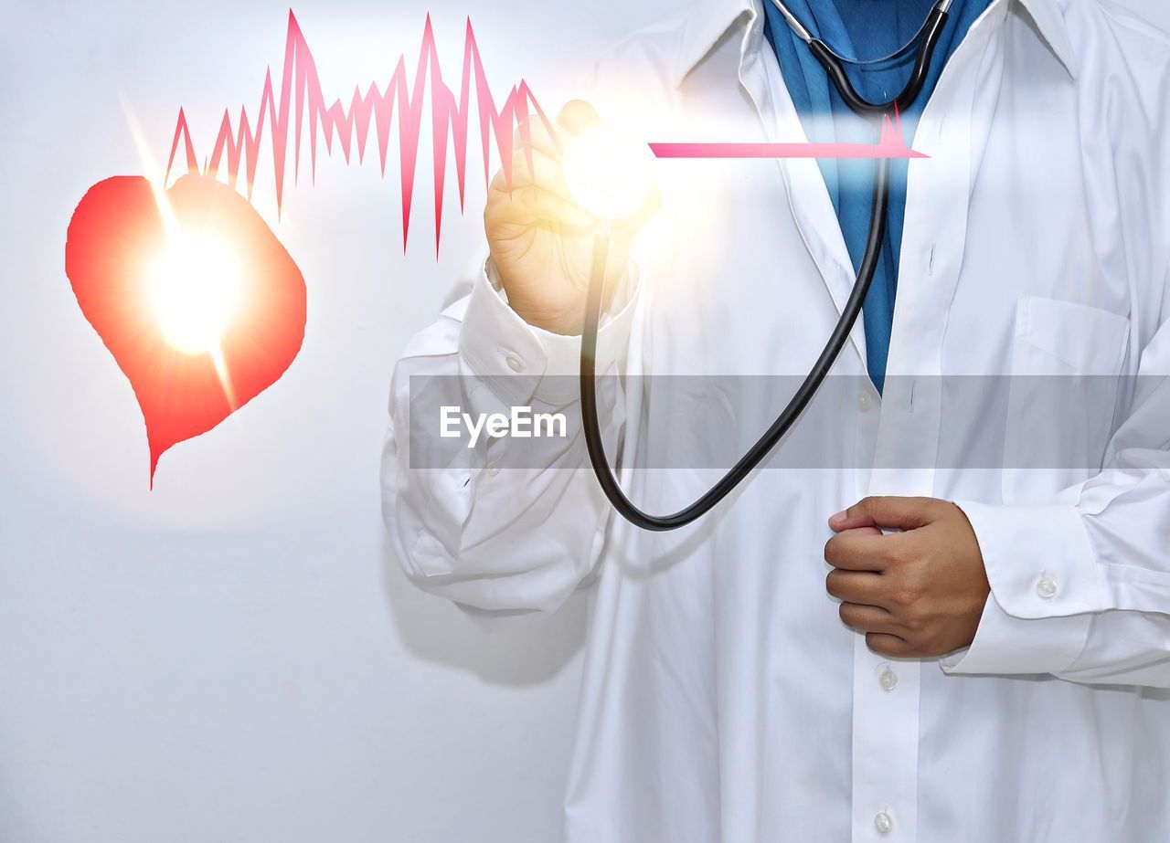 Digital composite image of doctor examining pulse rate with stethoscope