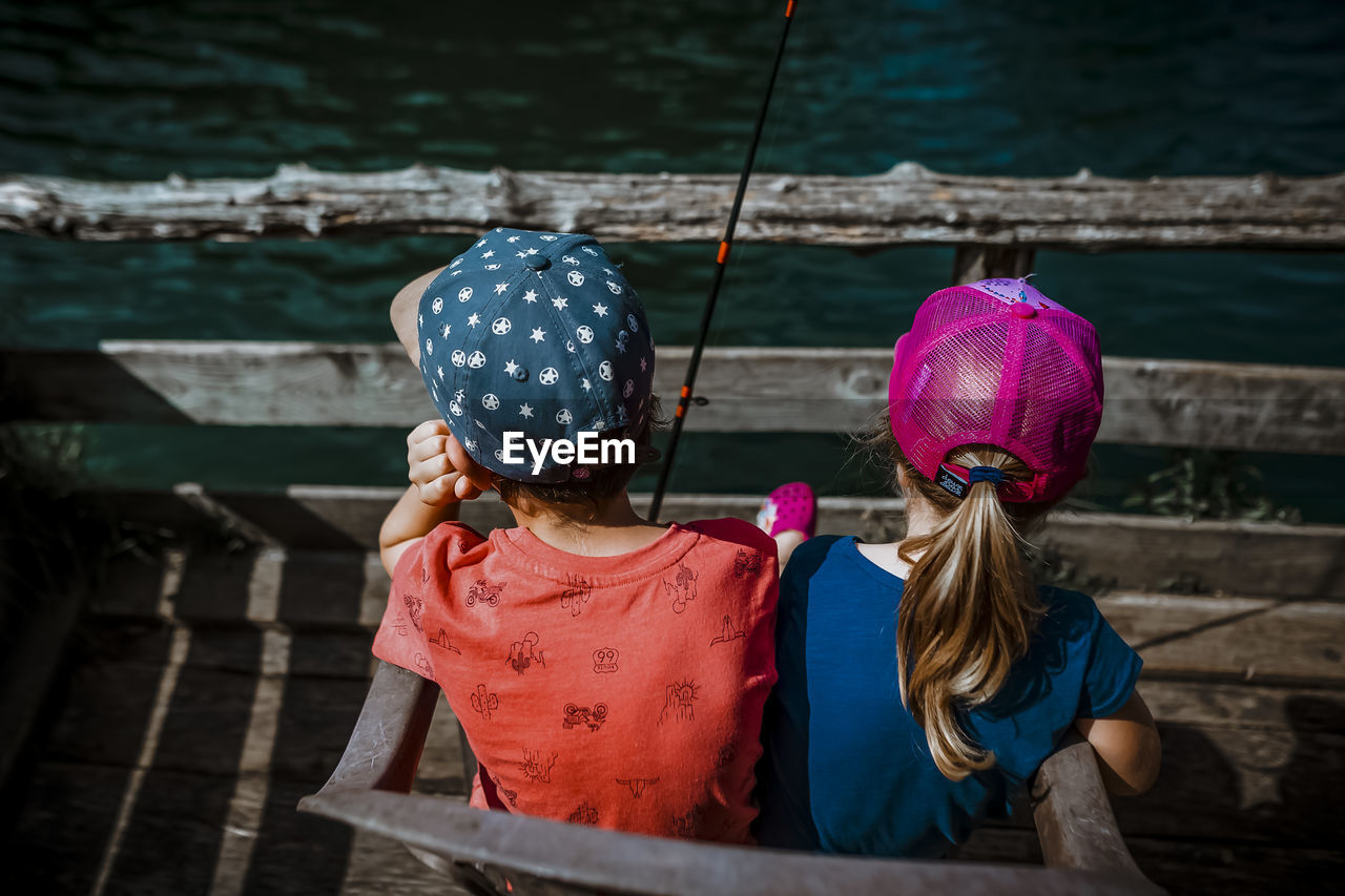 Siblings fishing and waiting on a sunny day