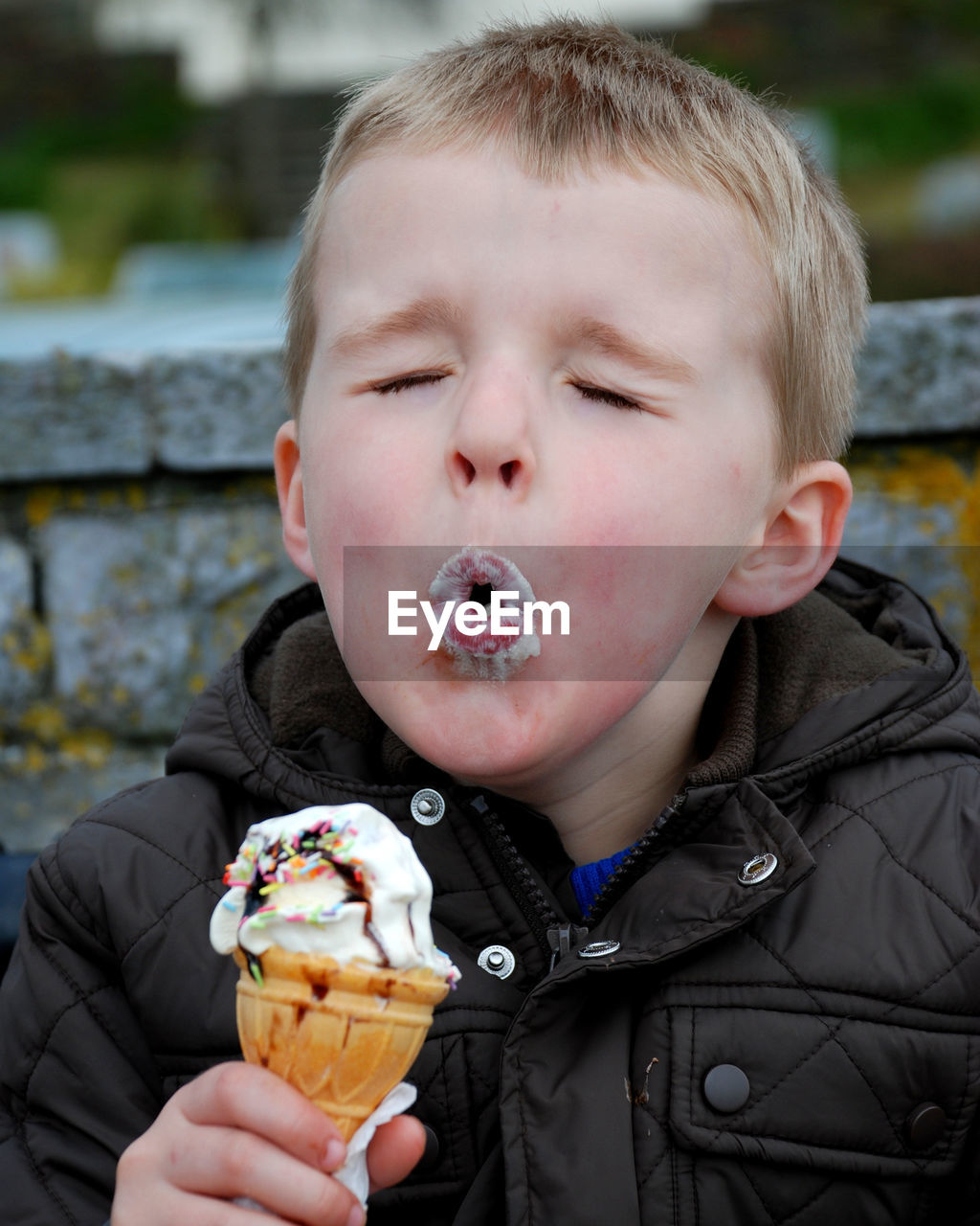 Close-up of cute boy with eyes closed eating ice cream