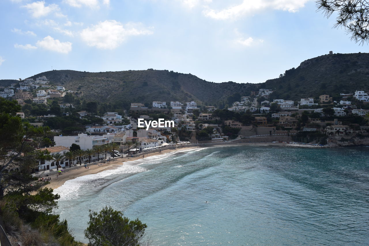 Scenic view of sea by town against sky