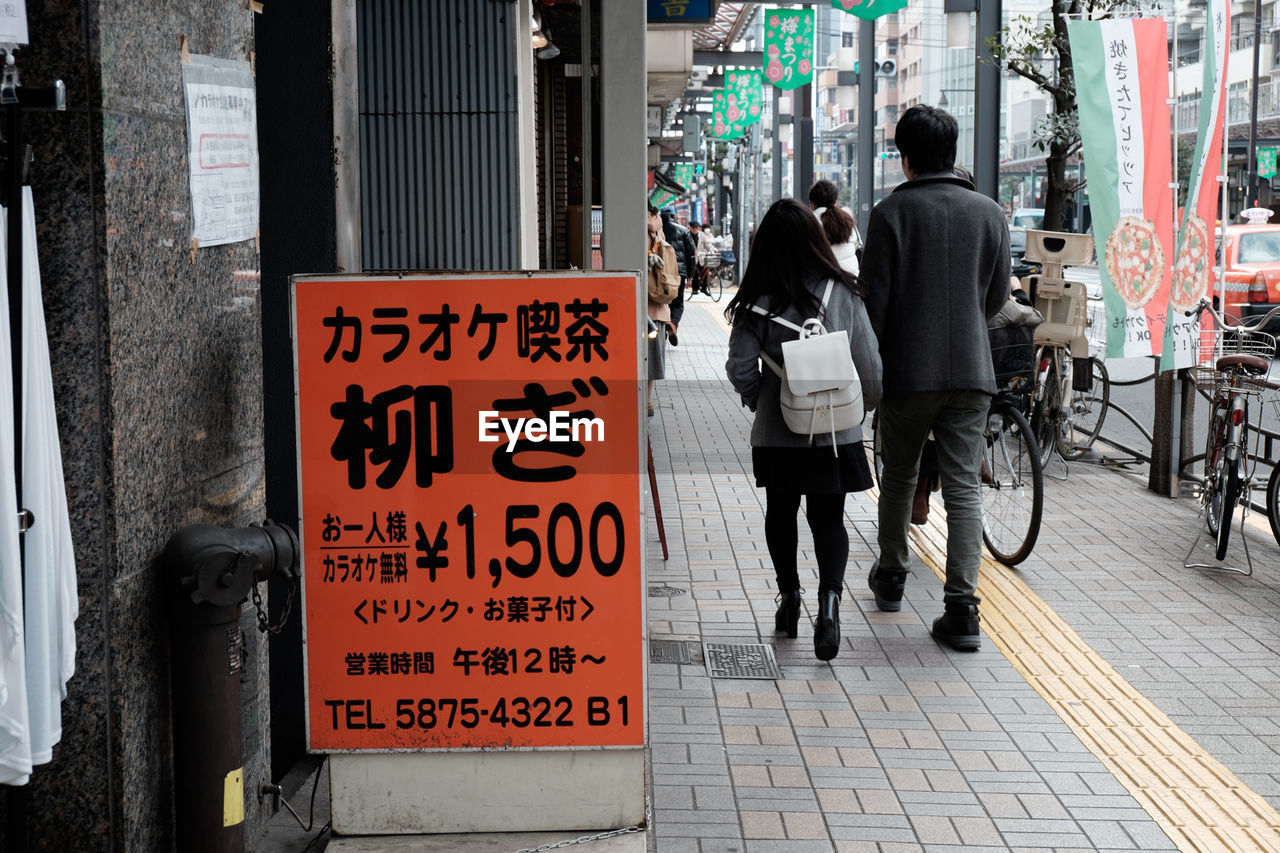 Commercial sign outside store by footpath