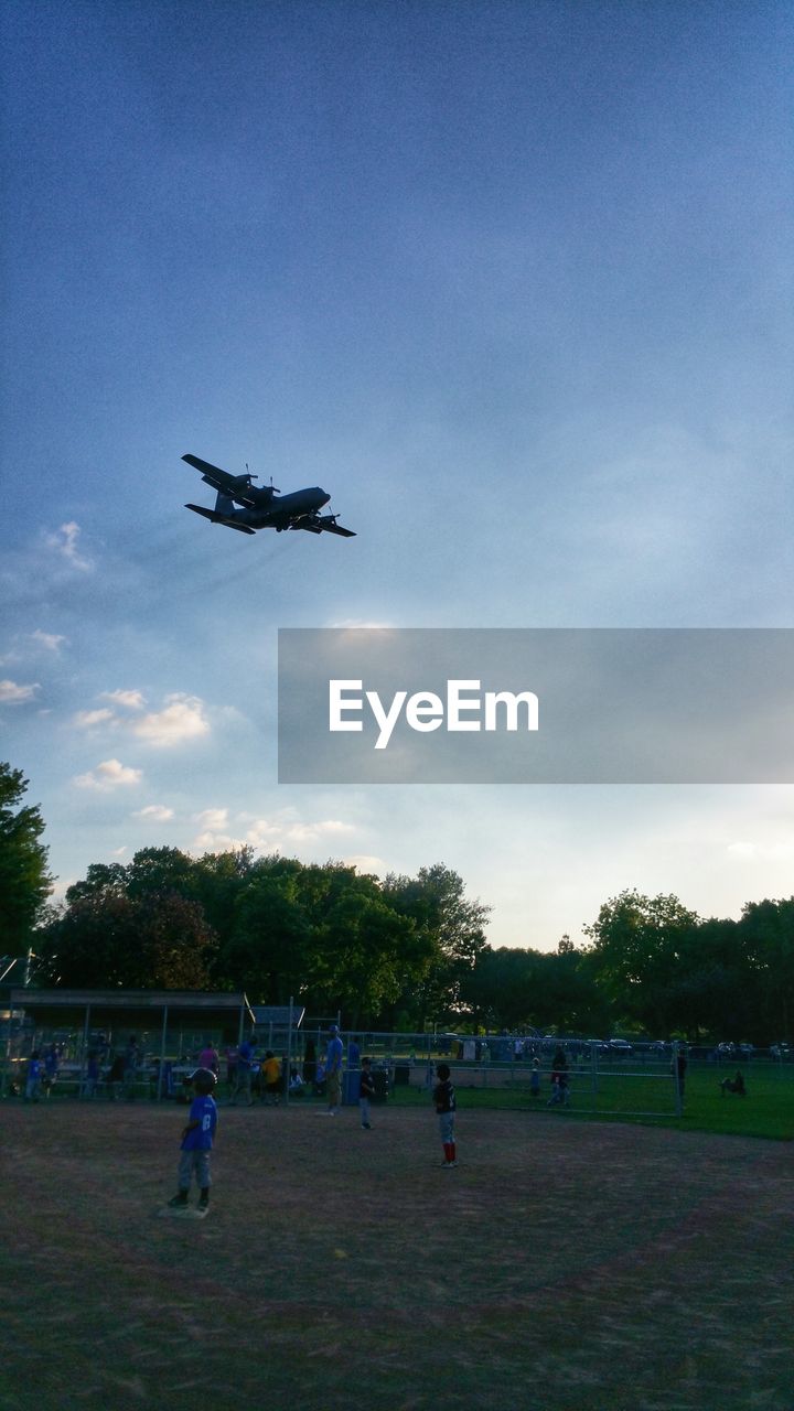 Airplane flying over baseball field