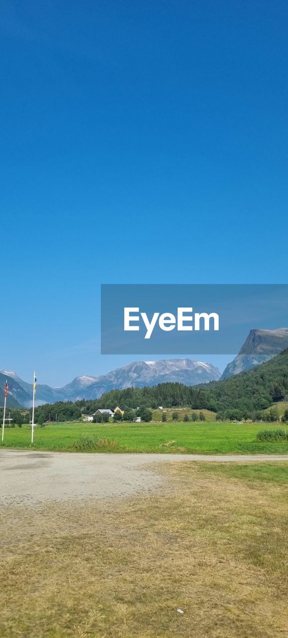 SCENIC VIEW OF LANDSCAPE AND MOUNTAINS AGAINST BLUE SKY