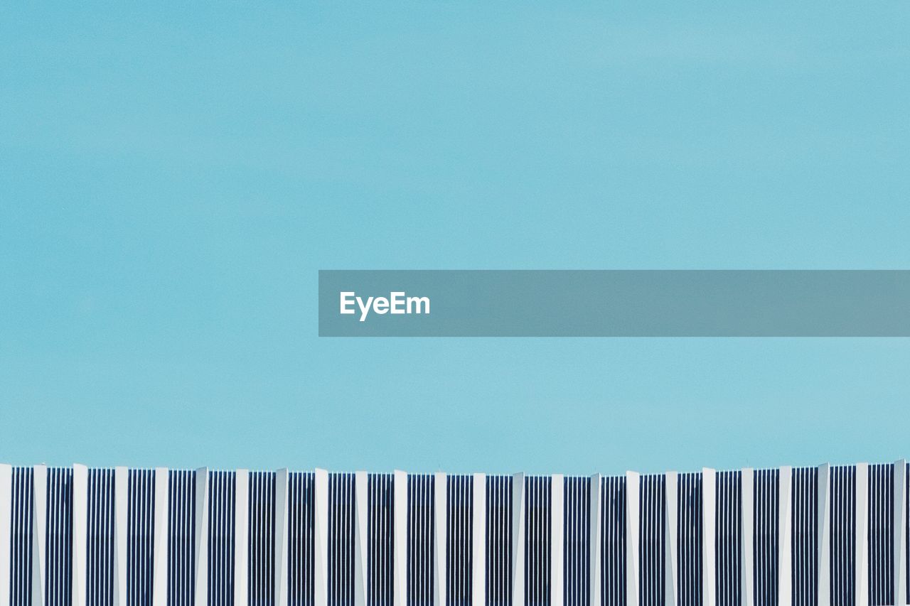 Low angle view of wall against clear blue sky