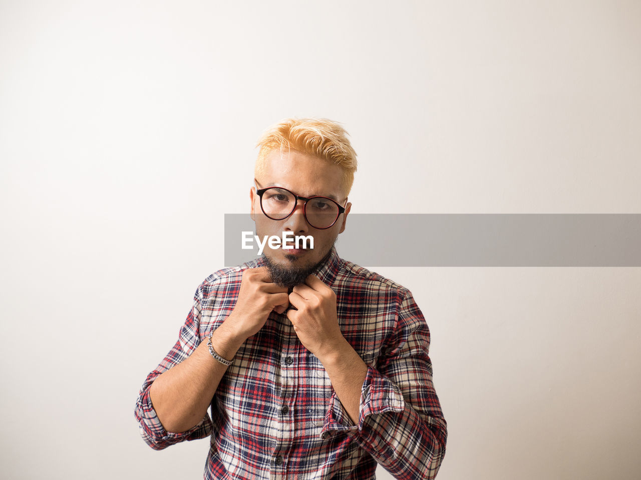 PORTRAIT OF HANDSOME YOUNG MAN AGAINST WHITE BACKGROUND