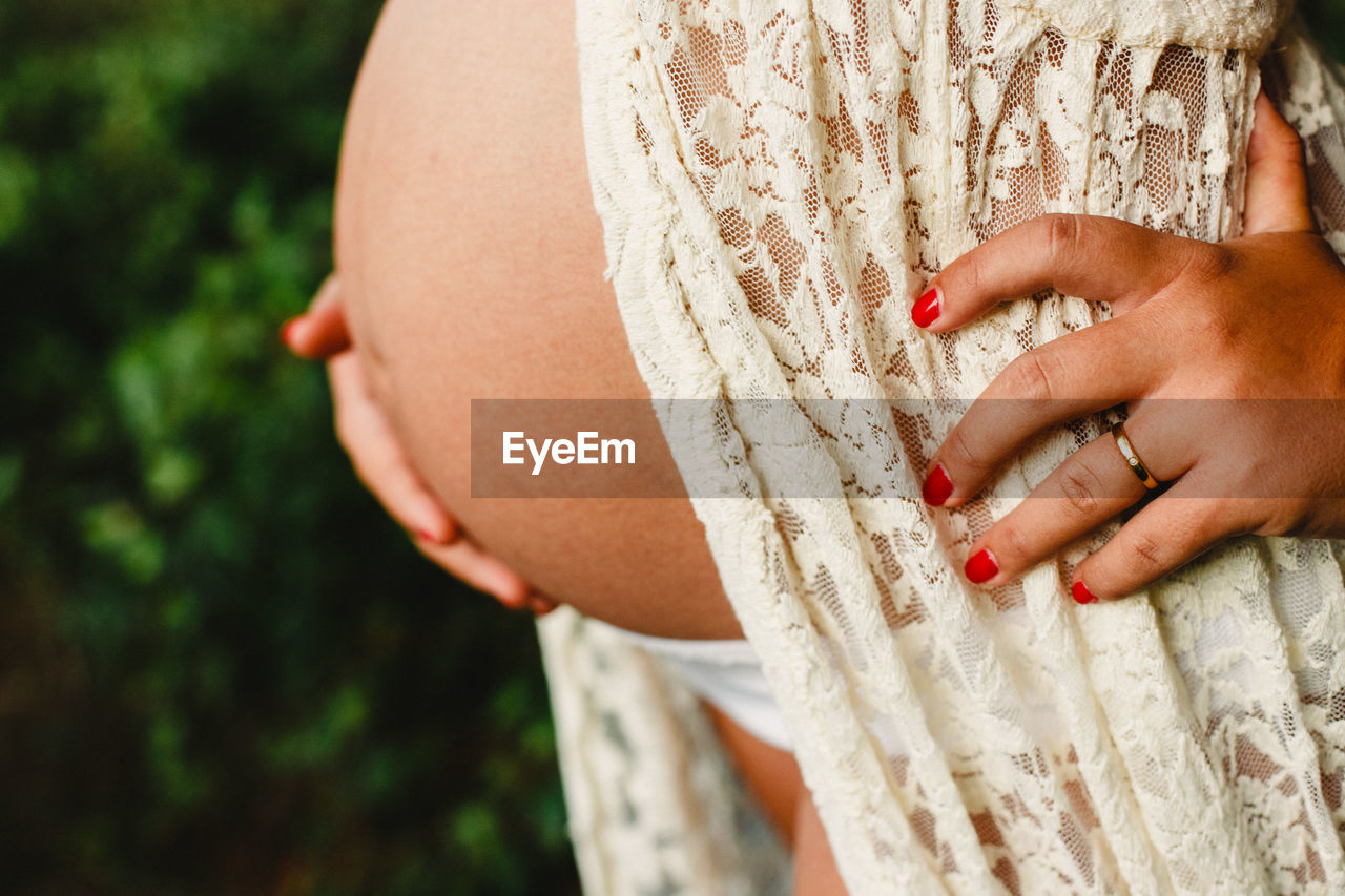 Midsection of pregnant woman standing outdoors