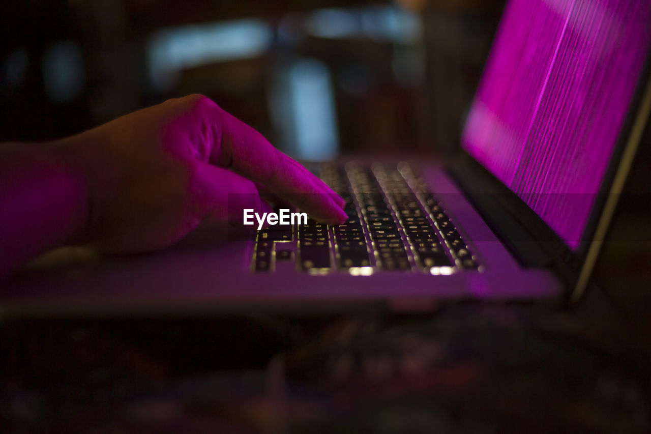 Close-up of hand using keyboard laptop