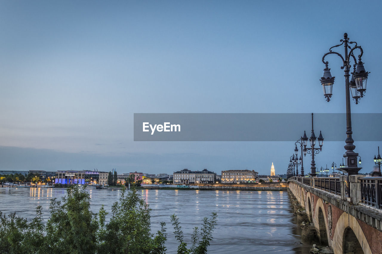 River by cityscape against sky