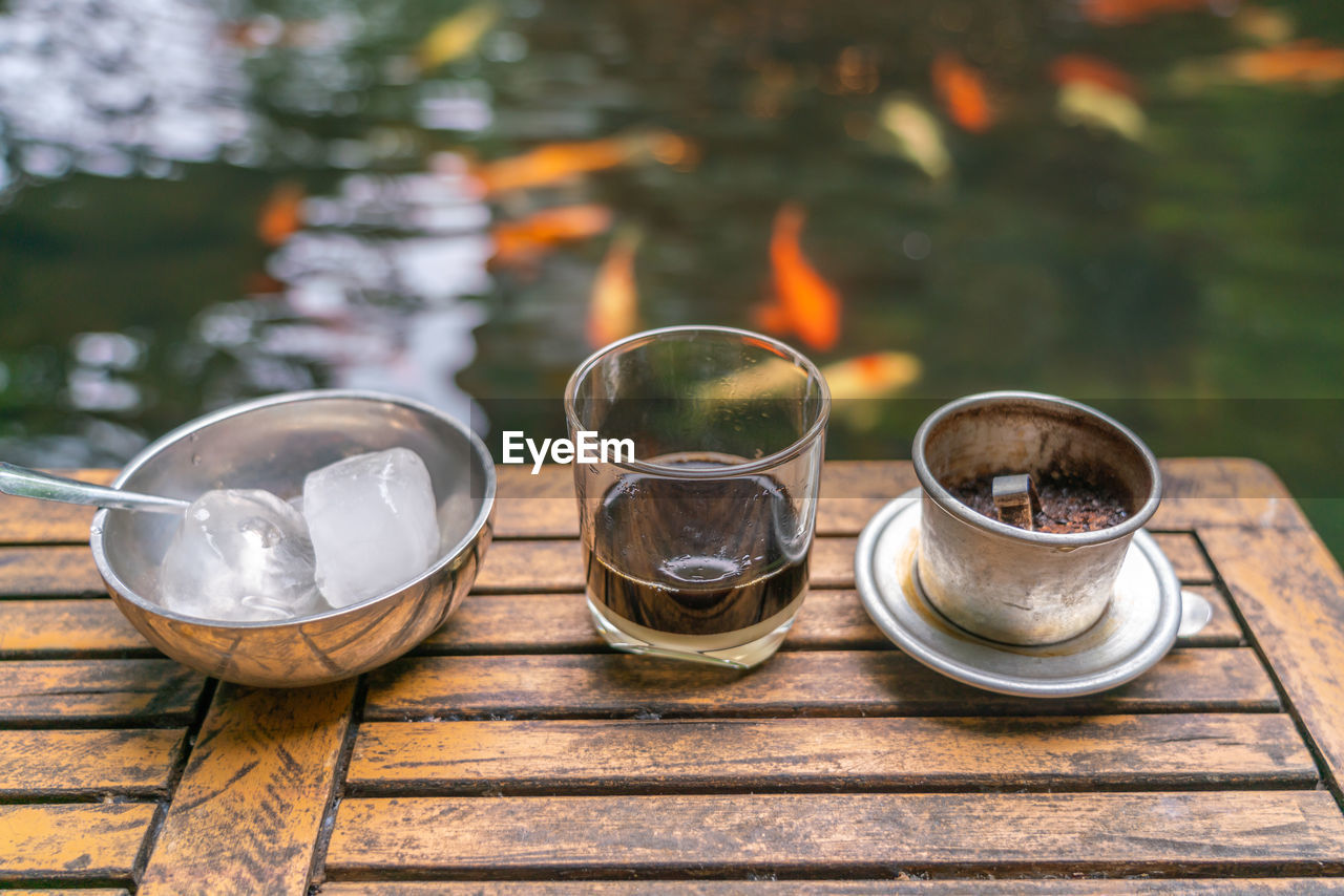 Traditional vietnamese coffee with the koi fish pond background