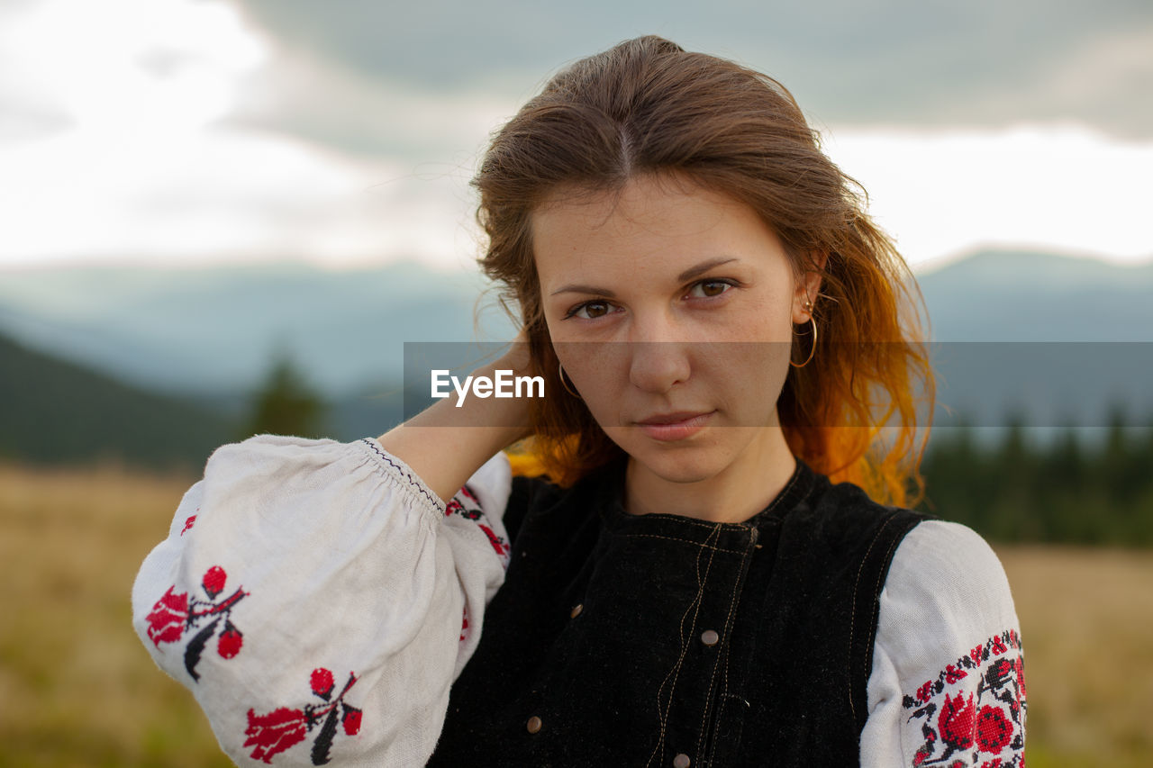 Portrait of a girl in embroidery in the mountains