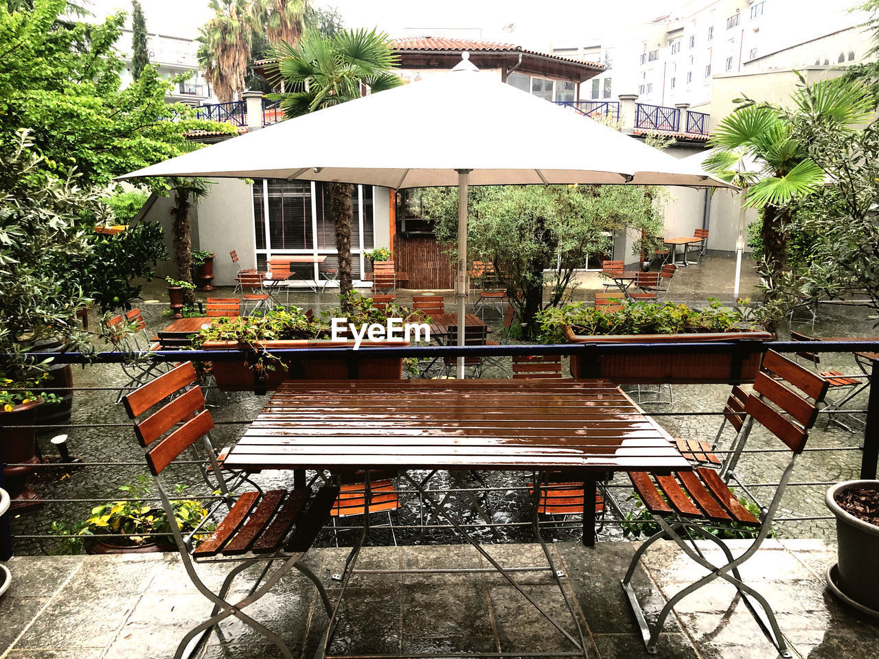 EMPTY CHAIRS AND TABLE AGAINST BUILDING