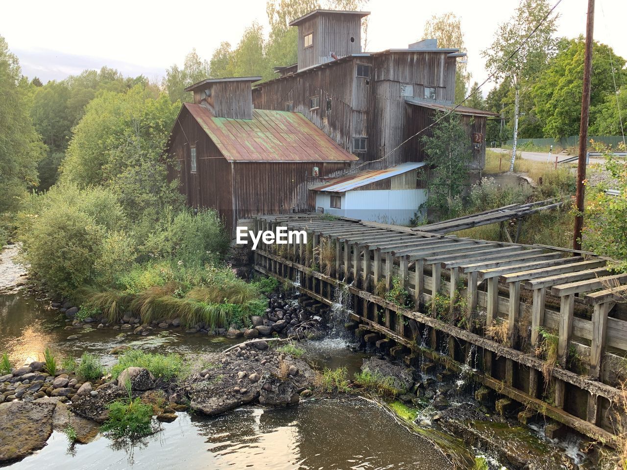 BUILT STRUCTURE BY RIVER AGAINST BUILDINGS