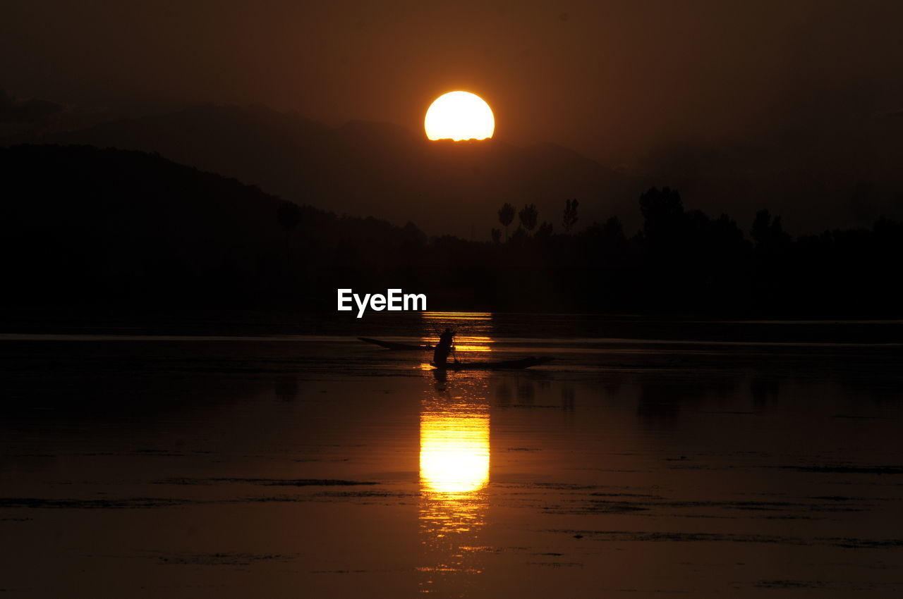 SCENIC VIEW OF LAKE AGAINST SKY AT SUNSET