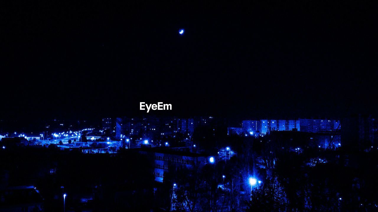 VIEW OF ILLUMINATED CITYSCAPE AT NIGHT