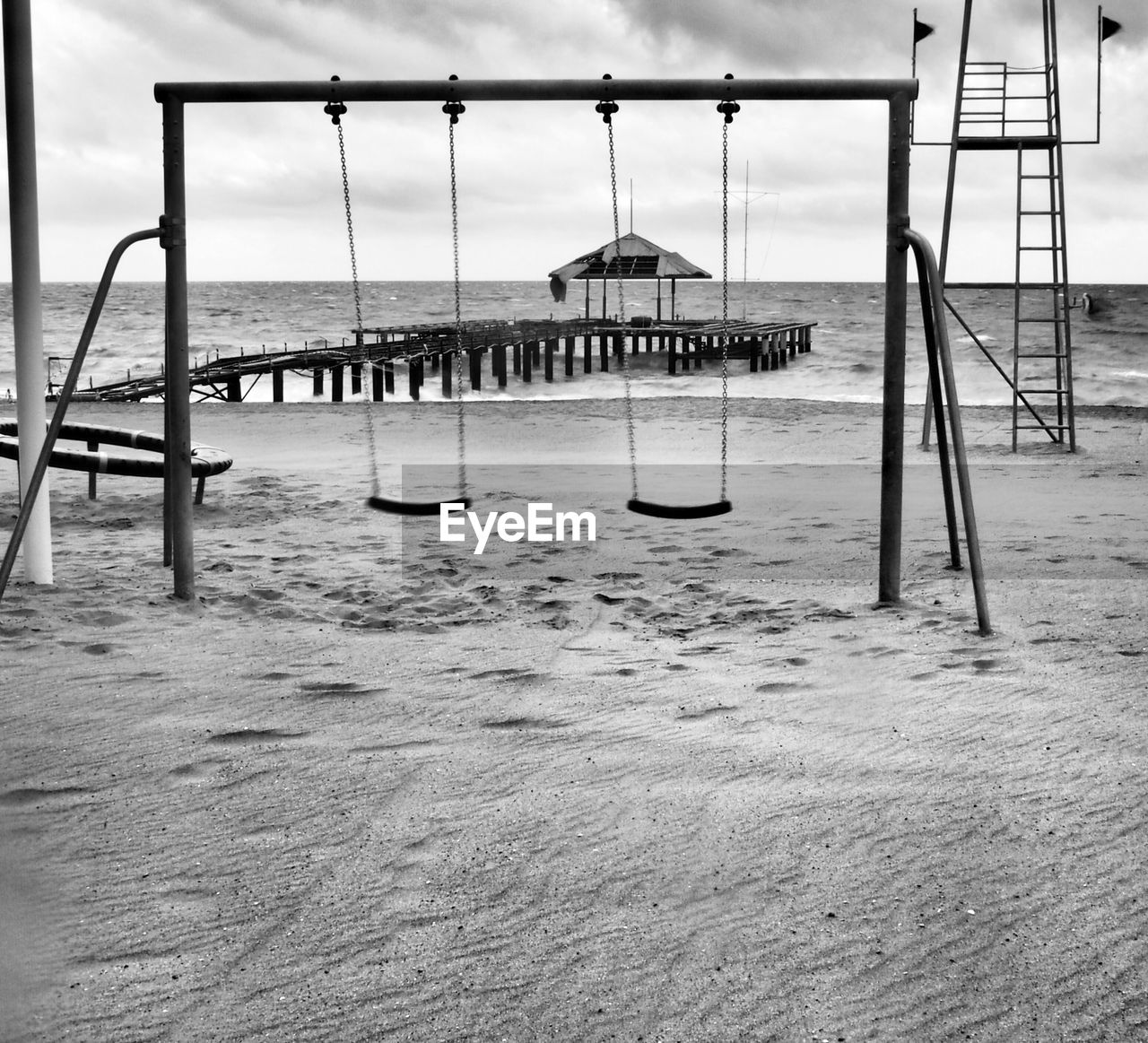 Empty swing set on beach