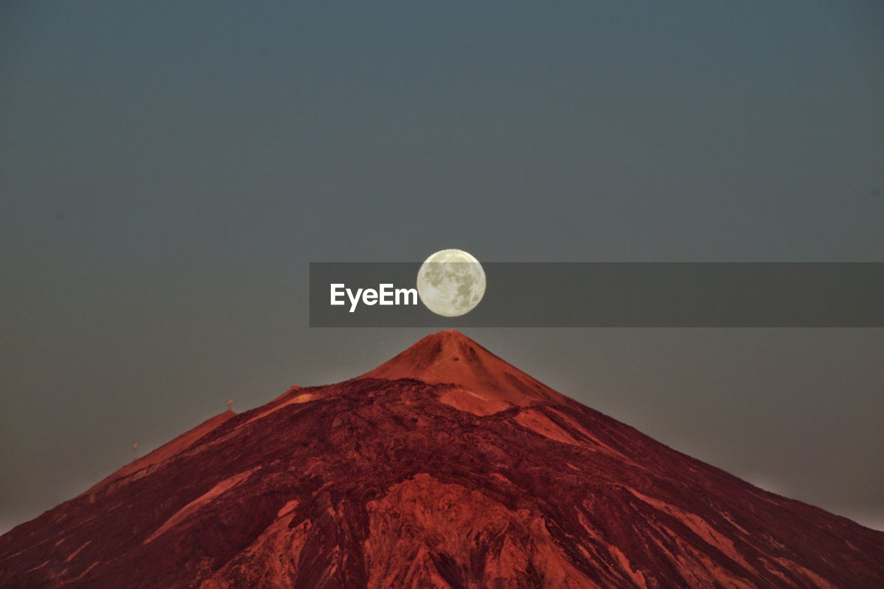 Low angle view of majestic mountain against sky at dusk