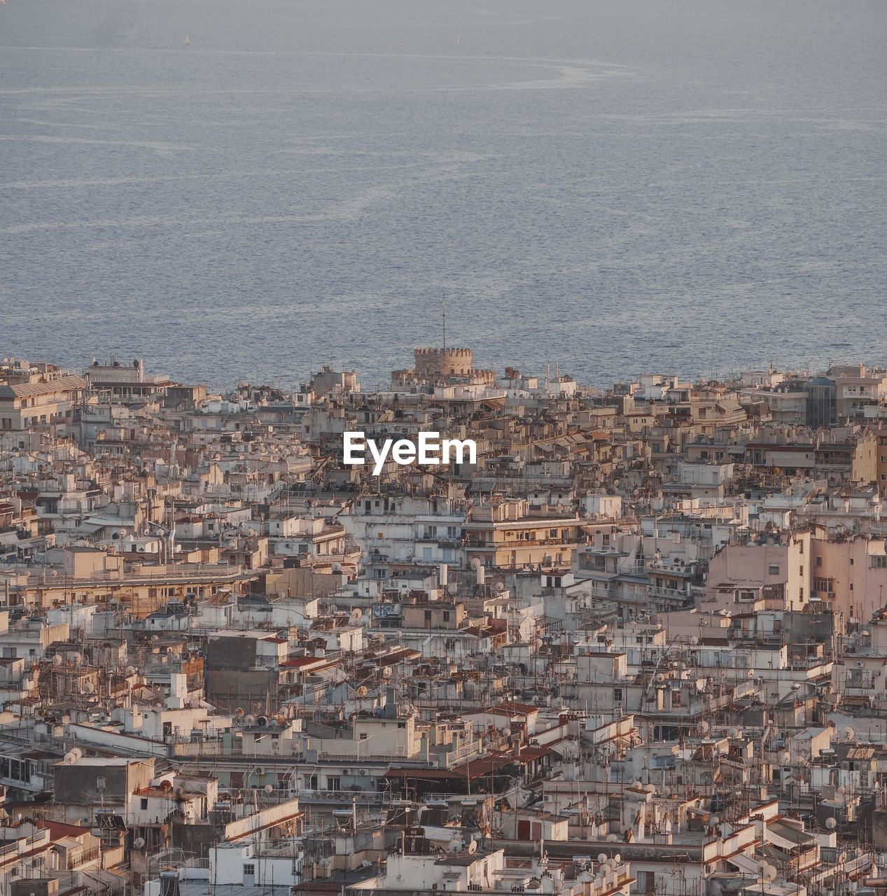 HIGH ANGLE SHOT OF TOWNSCAPE AGAINST SEA