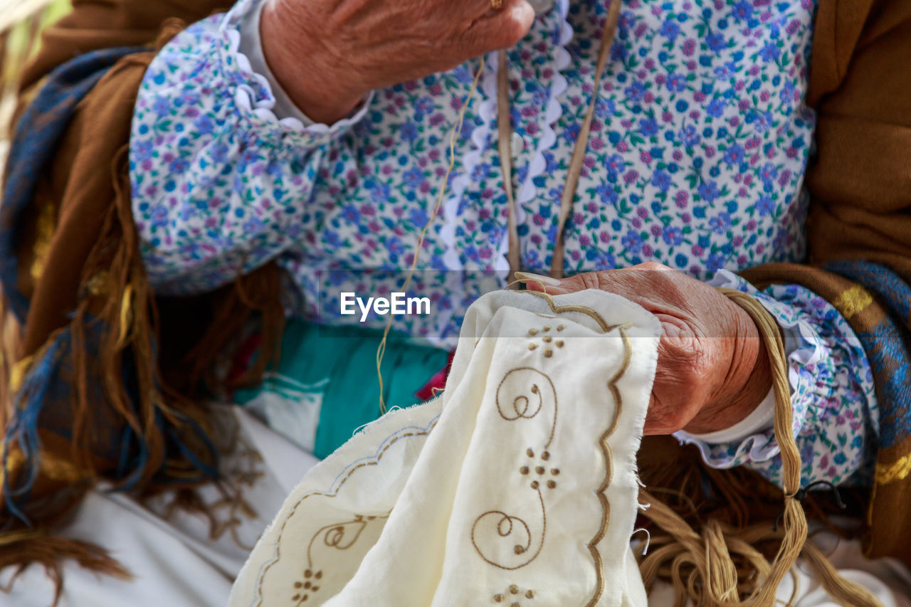 Midsection of woman sewing textile