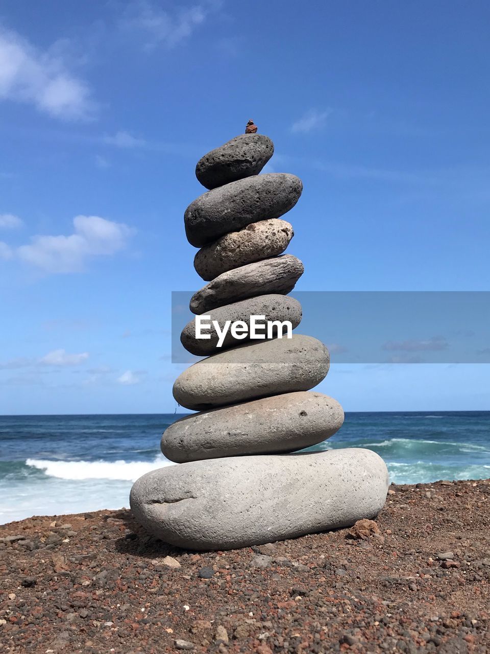 Stack of stones on beach against sky