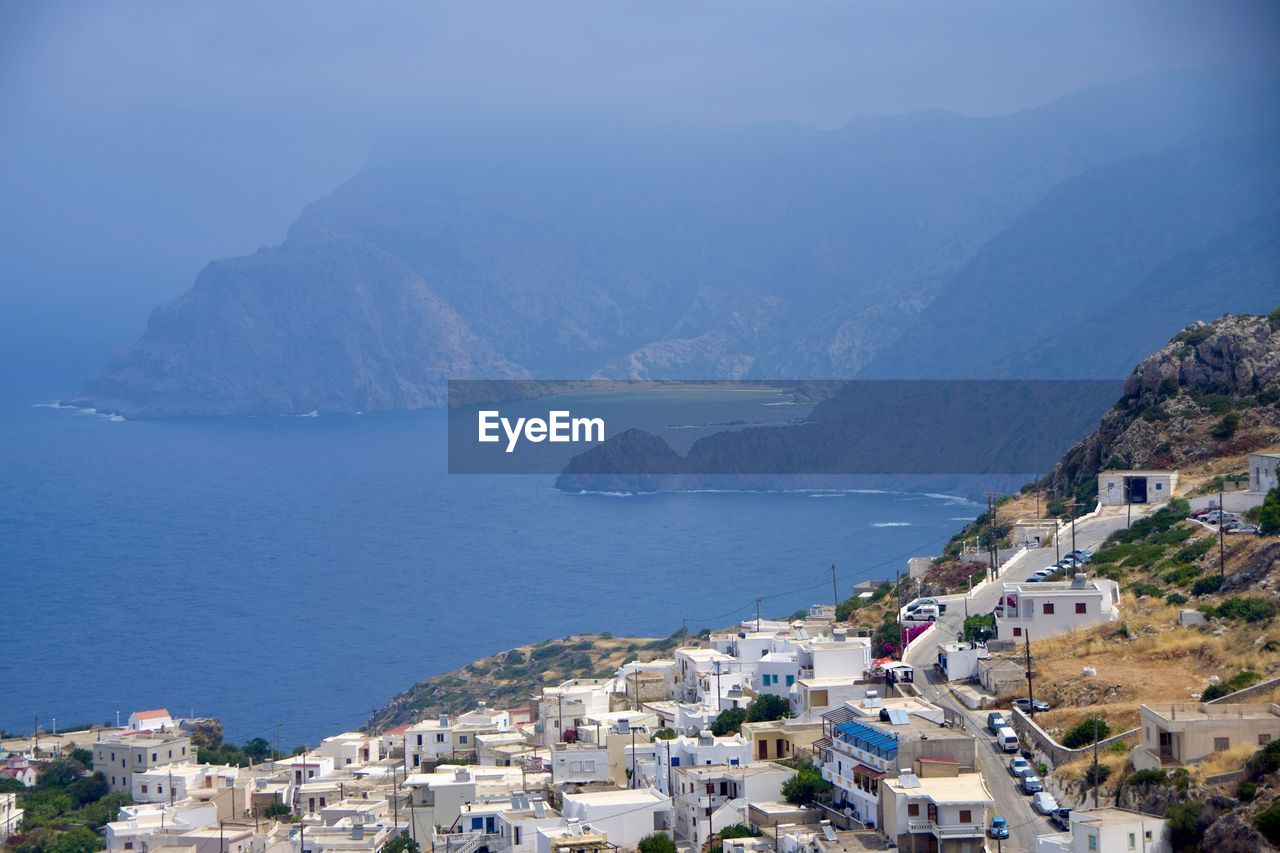 High angle view of townscape by sea against sky