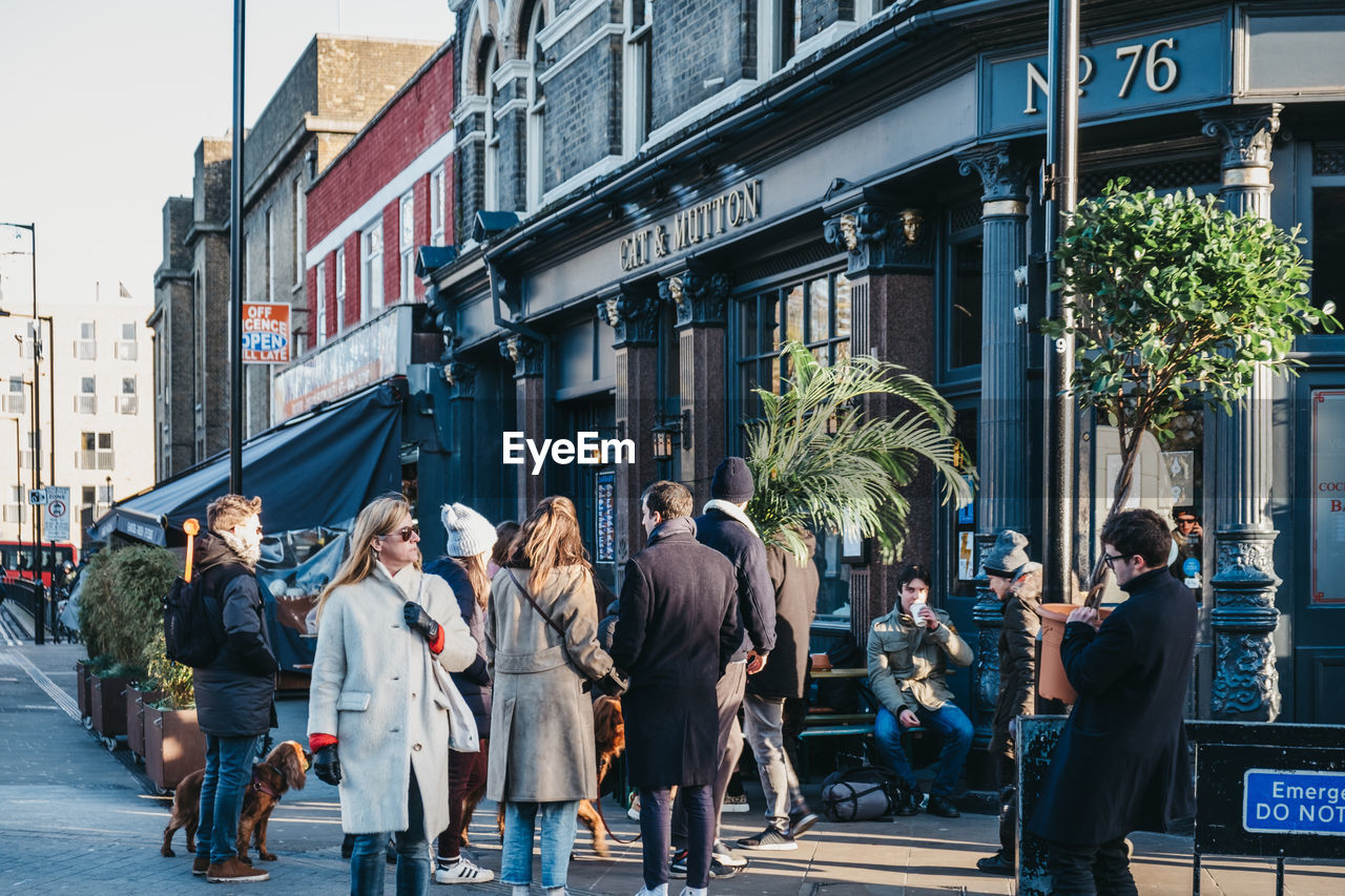 PEOPLE WALKING ON STREET IN CITY