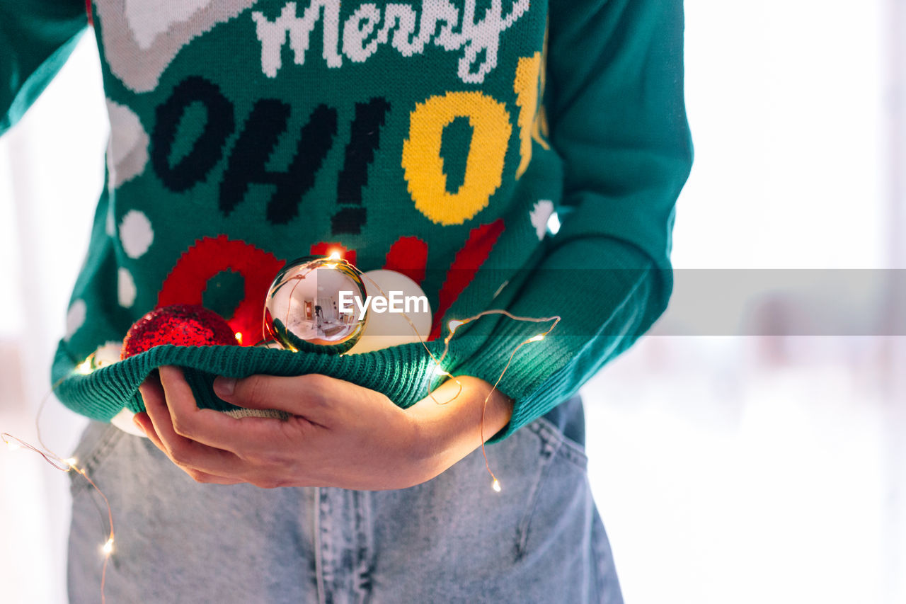 Midsection of woman holding christmas decoration