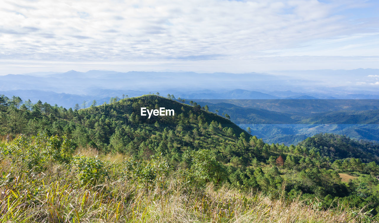 Scenic view of mountains against cloudy sky