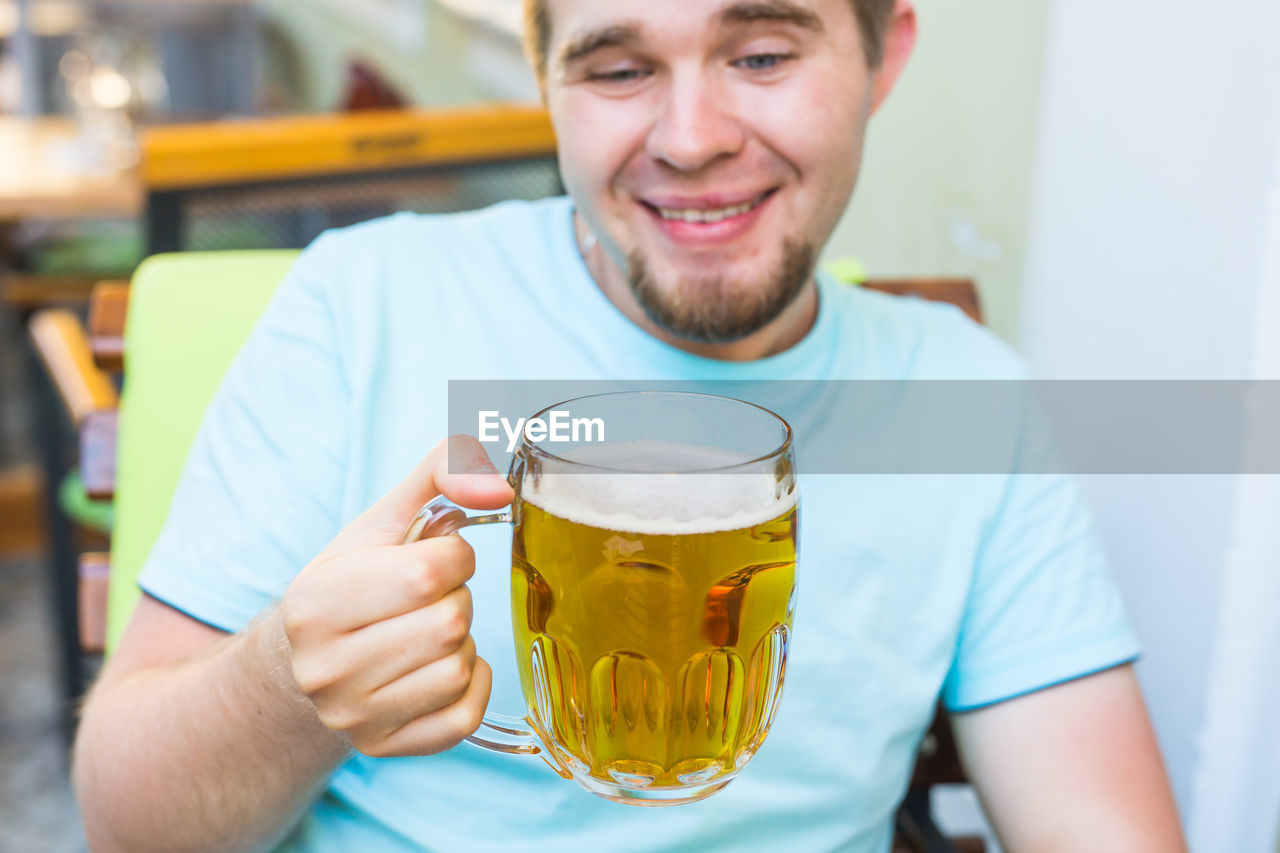 PORTRAIT OF A YOUNG MAN DRINKING GLASSES