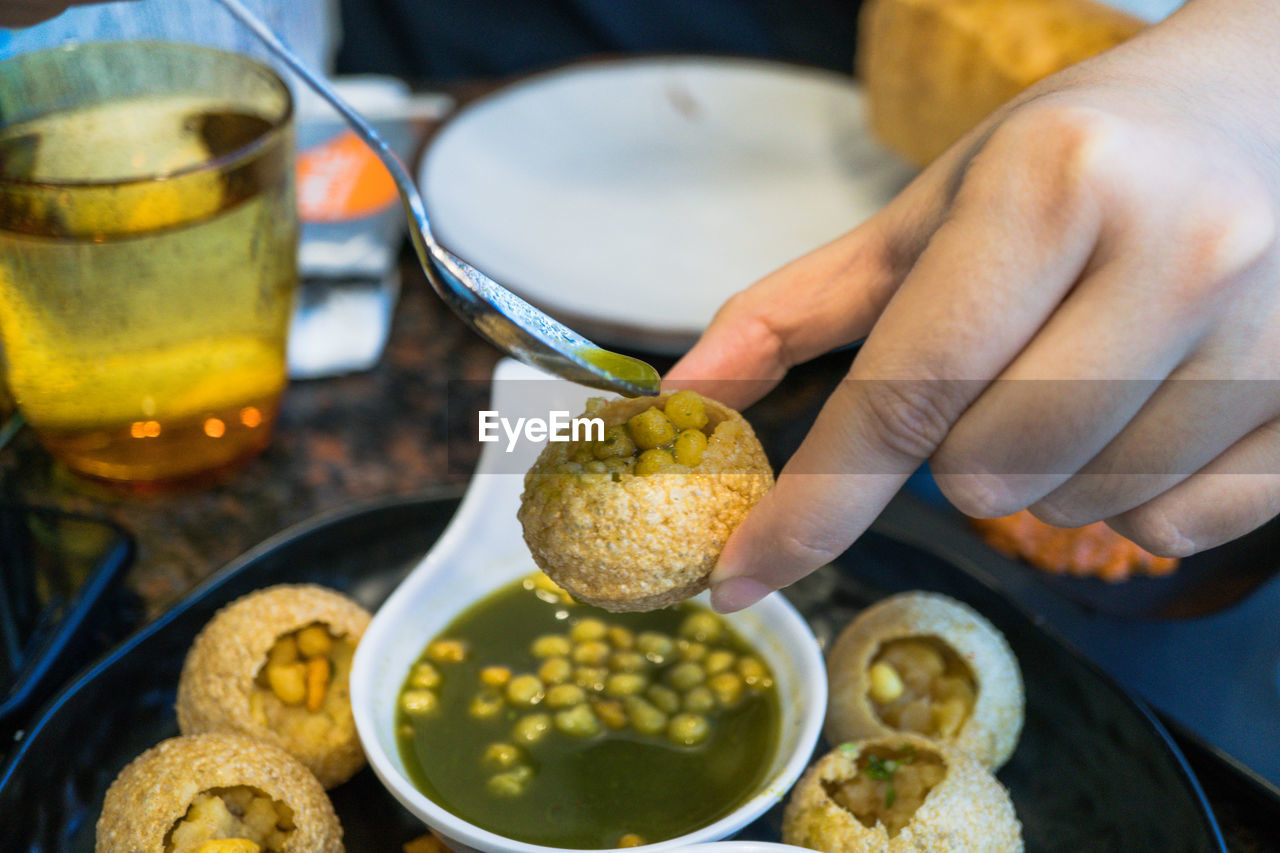 CLOSE-UP OF HAND HOLDING FOOD