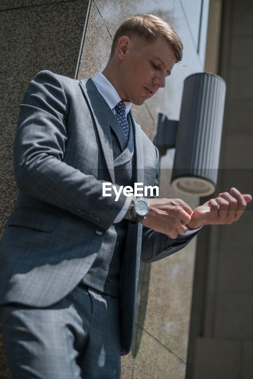 Low angle view of businessman against wall