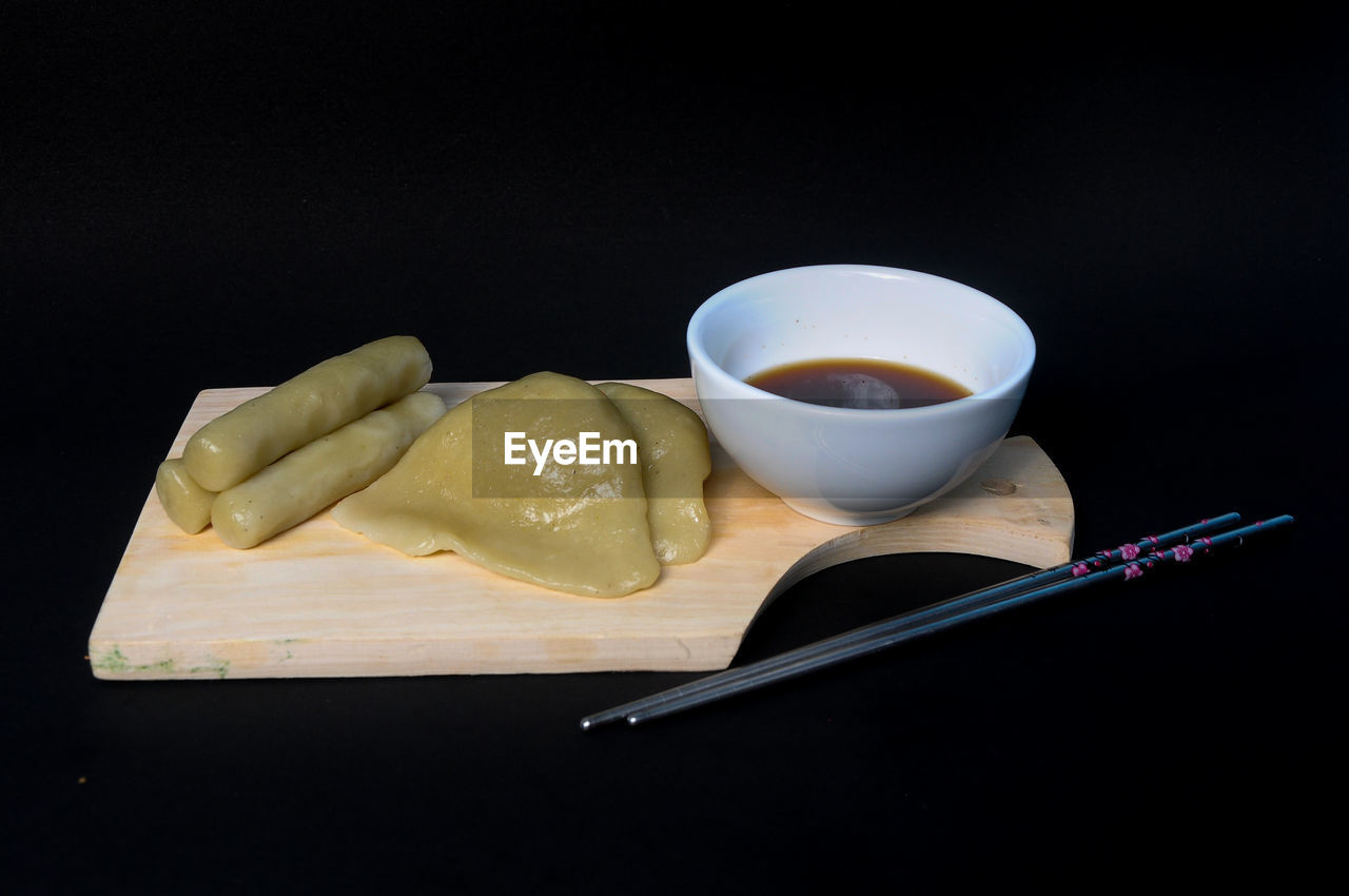 Close-up of pempek on table against black background