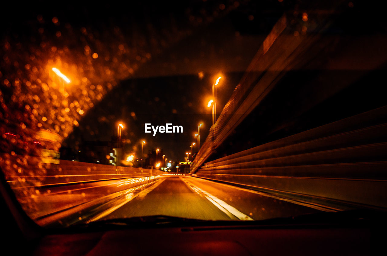Light trails seen through car windshield at night
