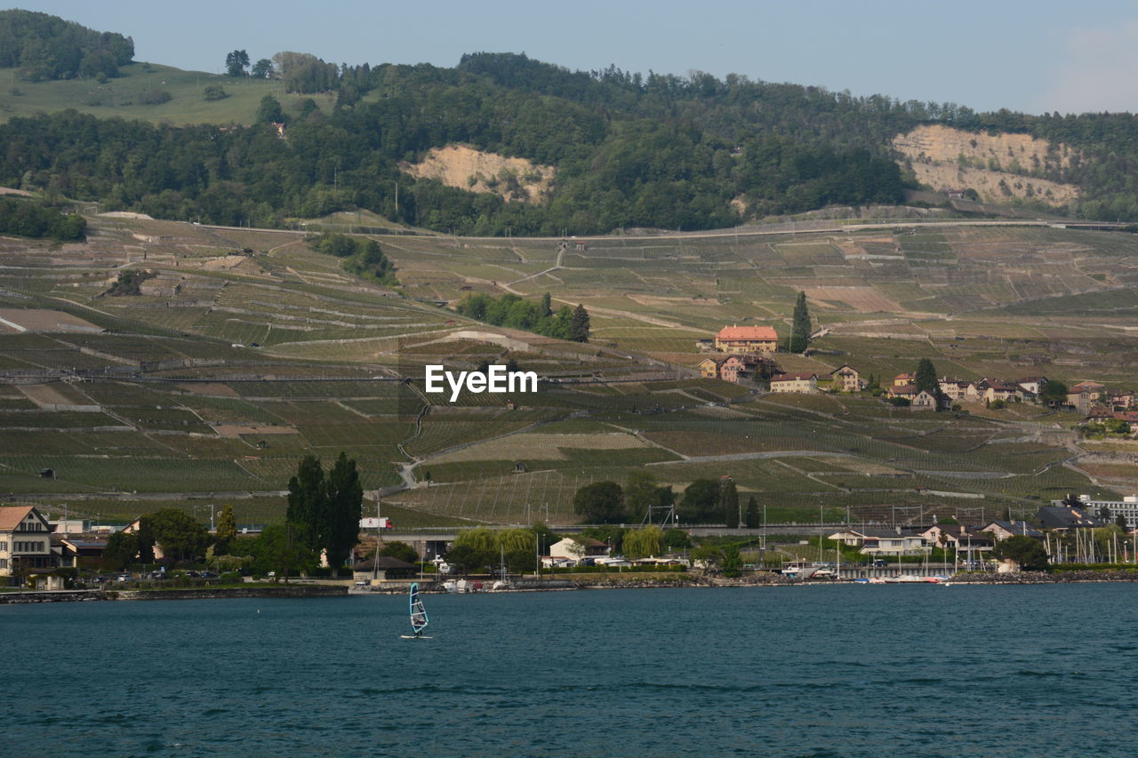 SCENIC VIEW OF LANDSCAPE AND BUILDINGS AGAINST MOUNTAIN