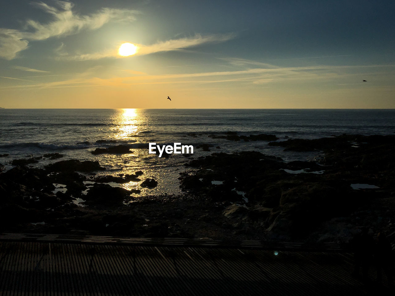 SCENIC VIEW OF BEACH AGAINST SKY DURING SUNSET