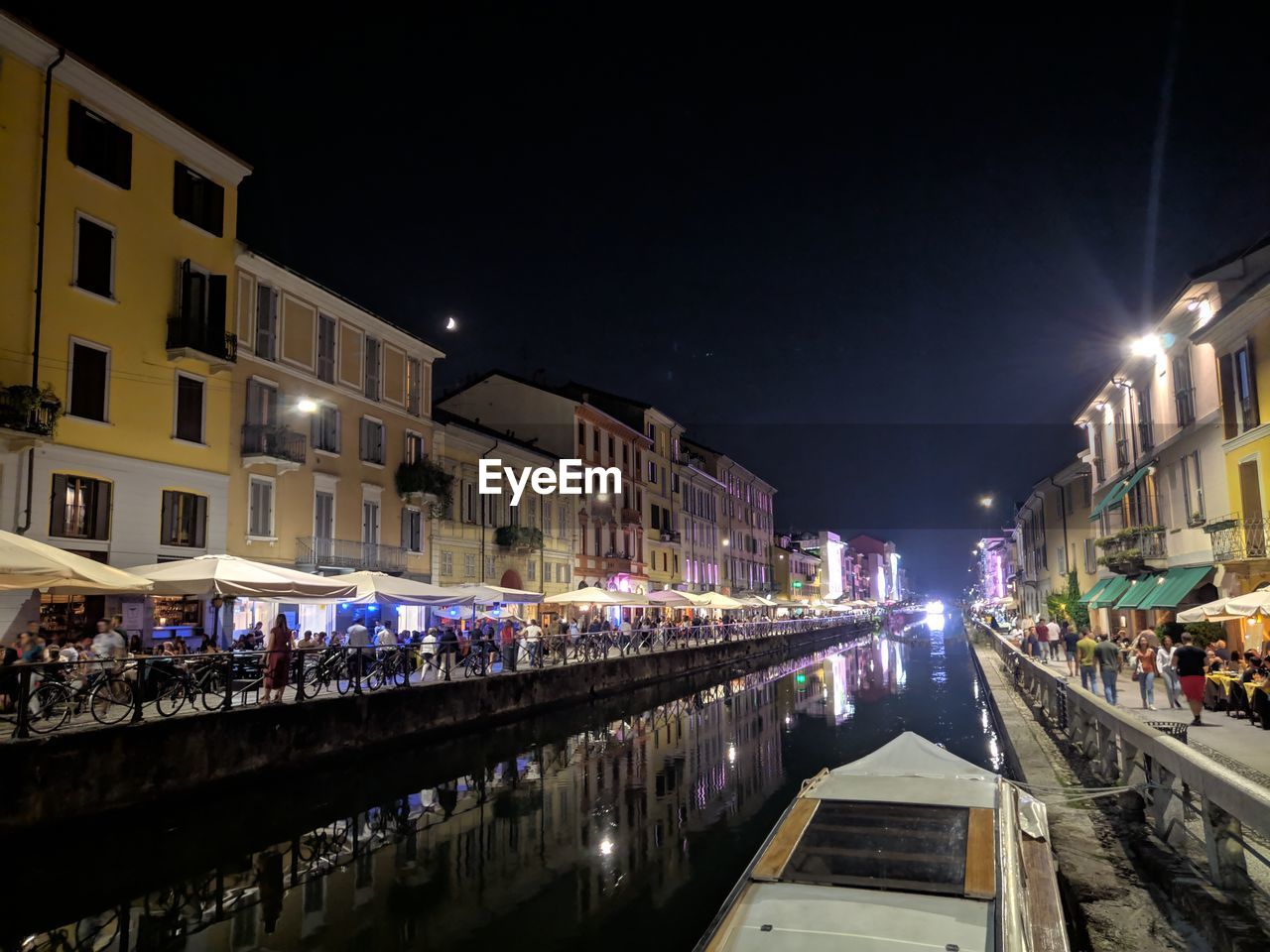 VIEW OF CANAL ALONG ILLUMINATED BUILDINGS AT NIGHT