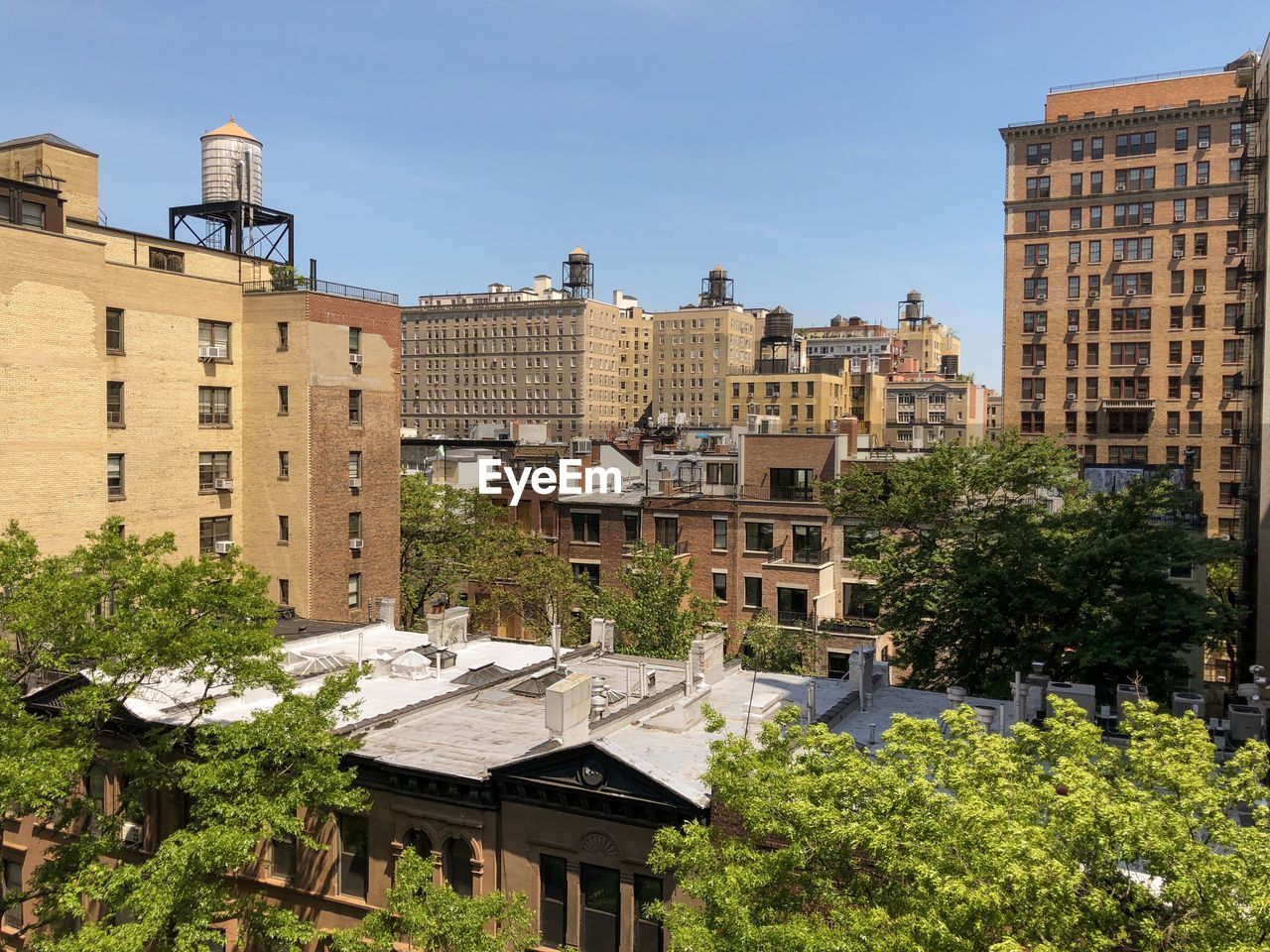View of upper west side skyline with classic brownstones and wooden water towers.