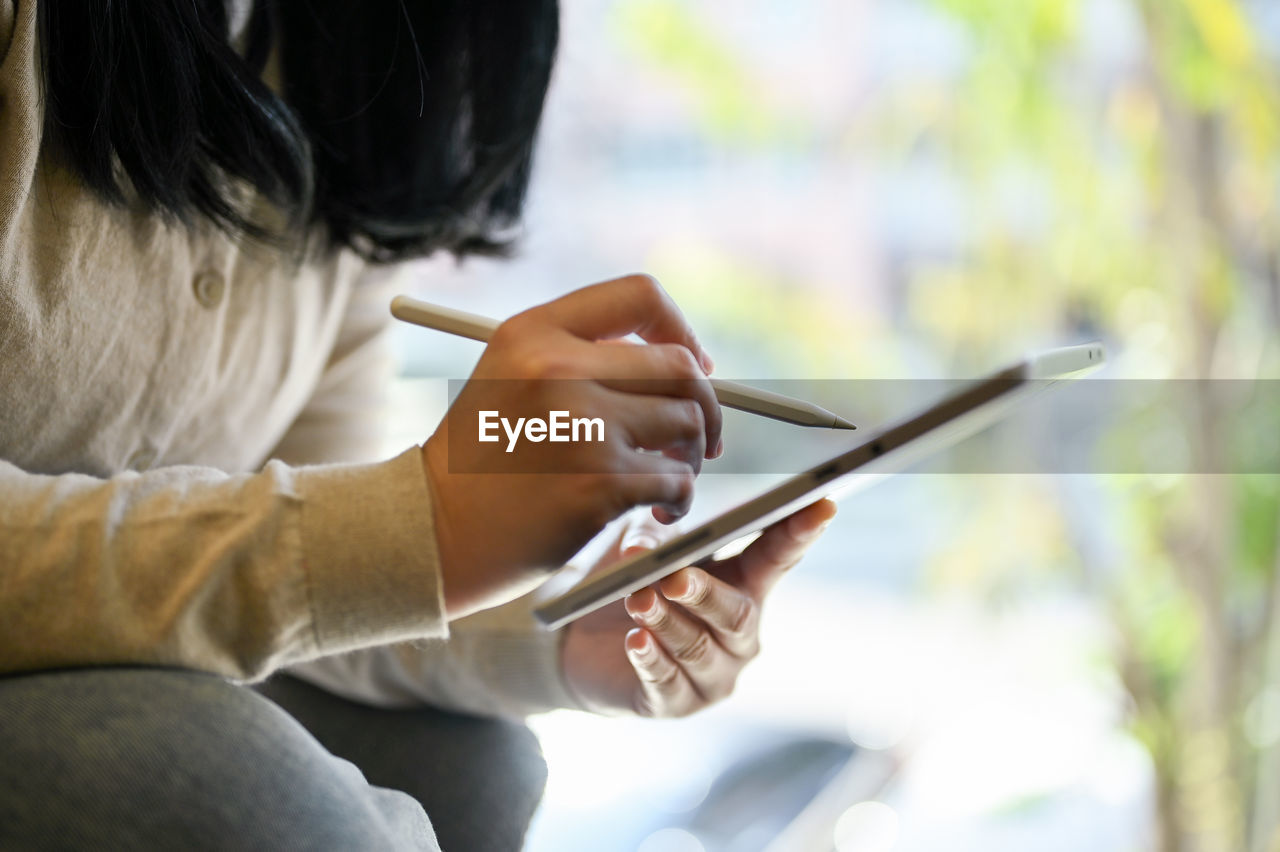 midsection of woman using digital tablet