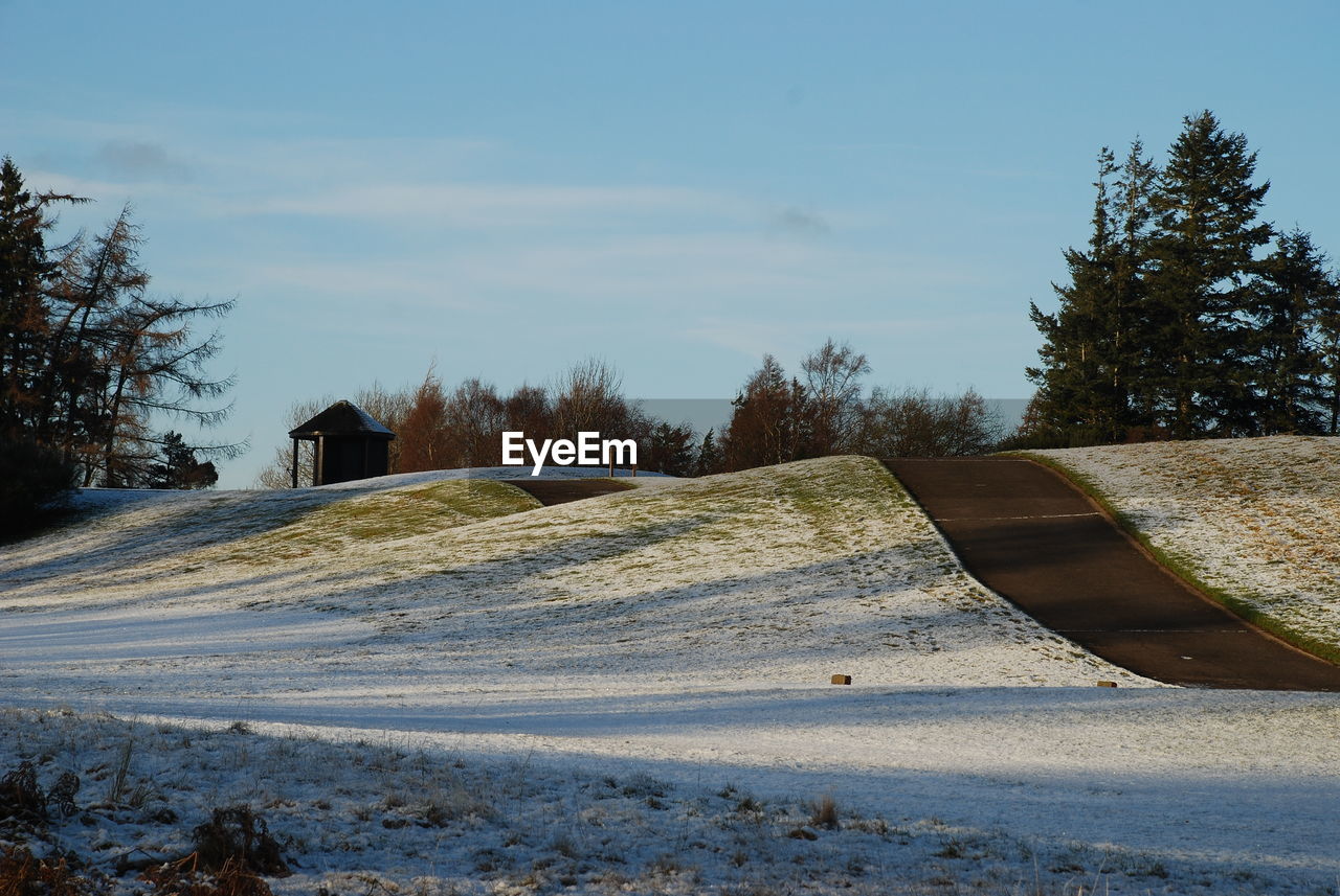 ROAD IN WINTER AGAINST SKY