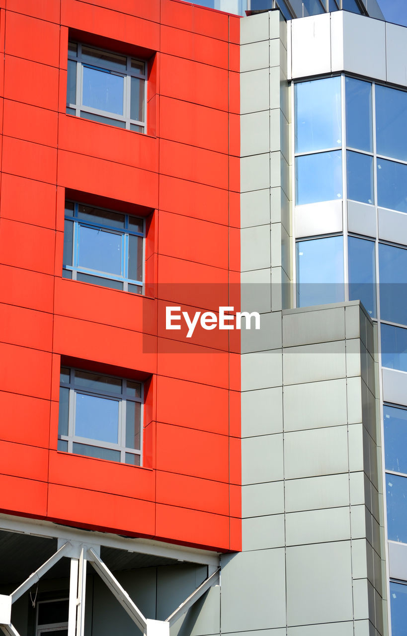 Abstract facade of a modern building. red, gray, blue color. square windows