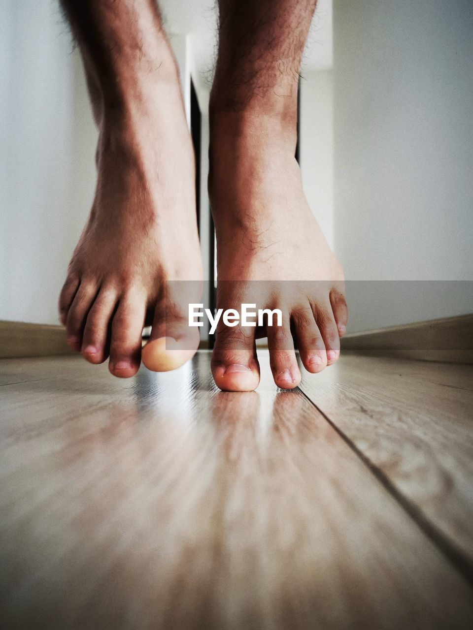barefoot, adult, low section, indoors, human leg, human foot, one person, flooring, toe, limb, close-up, human limb, hardwood floor, wood, lifestyles, men, hand, home interior, footwear