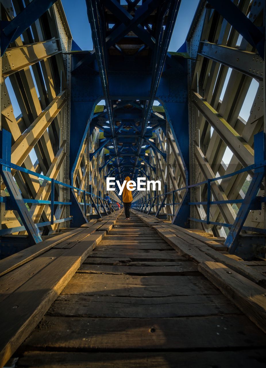 Rear view of man standing on footbridge