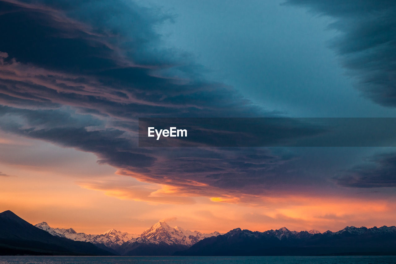 Scenic view of dramatic sky over lake during sunset