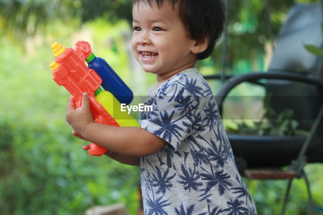 Cute boy playing with squirt gun